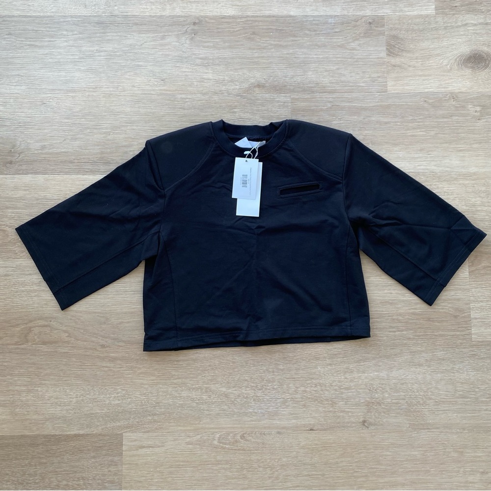 Cropped Fake Pocket Padded Shoulder T-shirt in black.